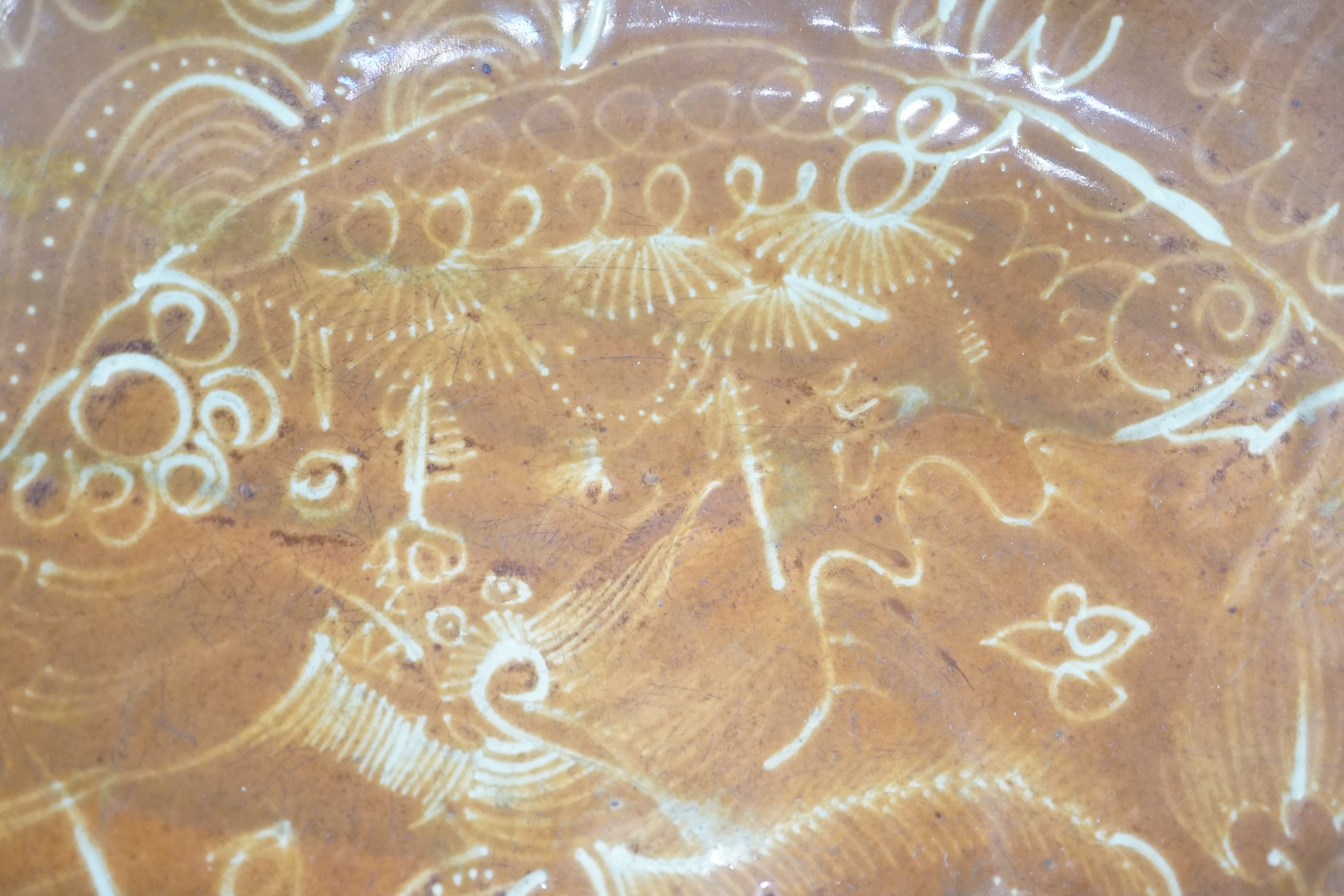 A Chinese Swatow slip-decorated brown ground dish, Zhangzhou kilns, early 17th century, 37cm diameter